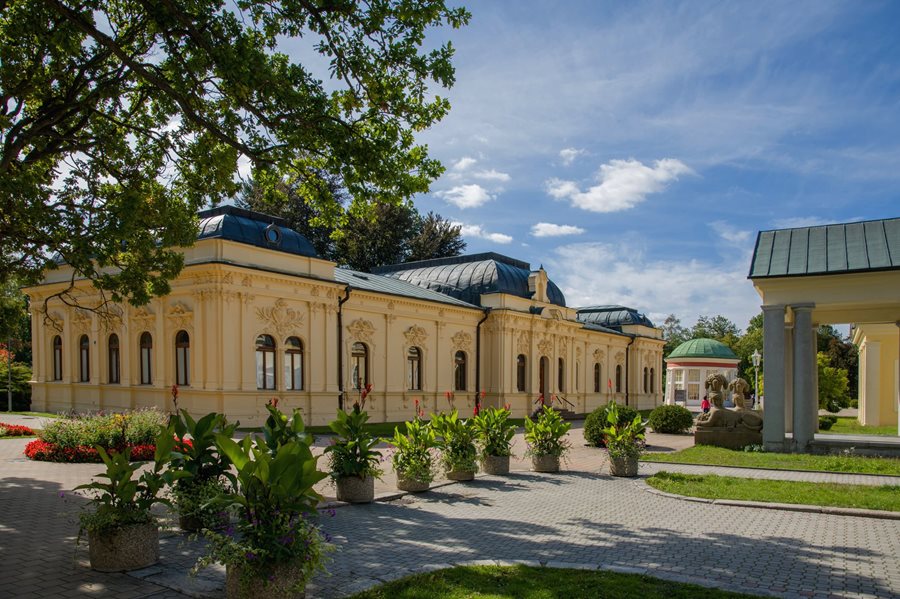 Historisch centrum van Františkovy Lázně met kleurrijke kuurgebouwen, bomen en een brede wandelpromenade.
