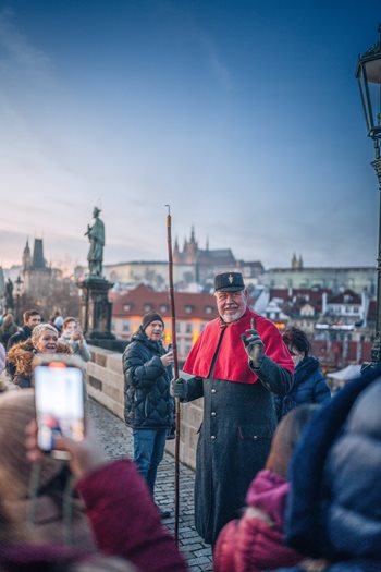 De lantaarnaansteker tijdens advent in Praag op de Karelsbrug