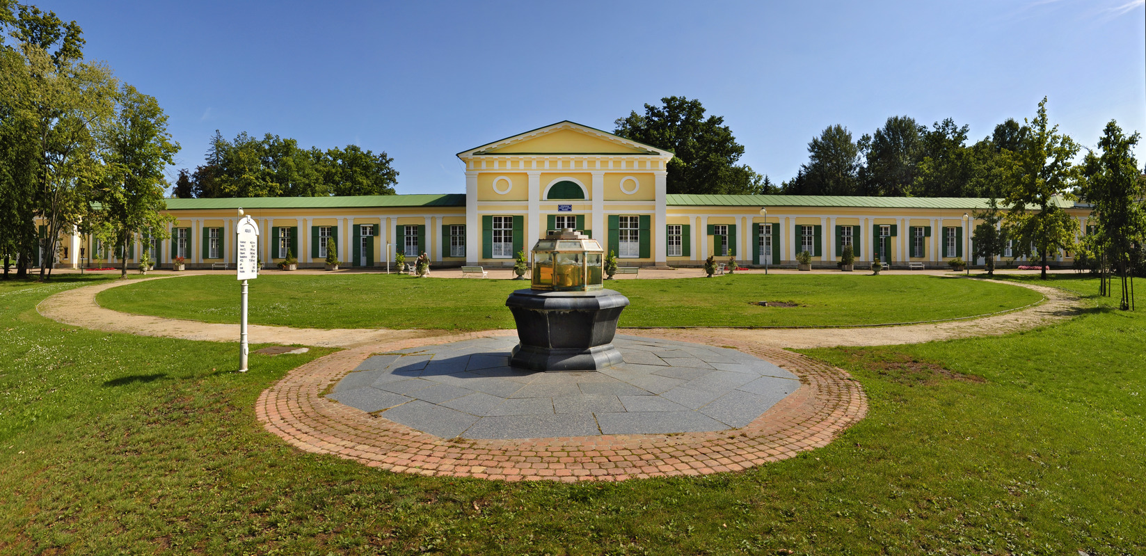 Historisch kuurgebouw in Františkovy Lázně met bron en gazon ervoor.